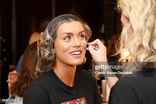 Model prepares backstage for Kaohs during the Paraiso Fashion Fair at The Setai Miami Beach on July 14, 2018 in Miami Beach, Florida.