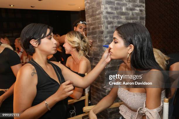 Model prepares backstage for Kaohs during the Paraiso Fashion Fair at The Setai Miami Beach on July 14, 2018 in Miami Beach, Florida.