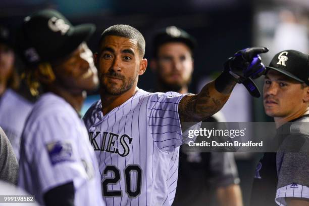 Ian Desmond of the Colorado Rockies points to first base as he laughs with Raimel Tapia after Desmond scored a run on an Nolan Arenado single in the...