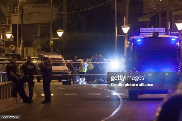 Police officers standing in the early morning at the location where police shot dead five terrorists in Cambrils, Spain, 18 August 2017. Police...