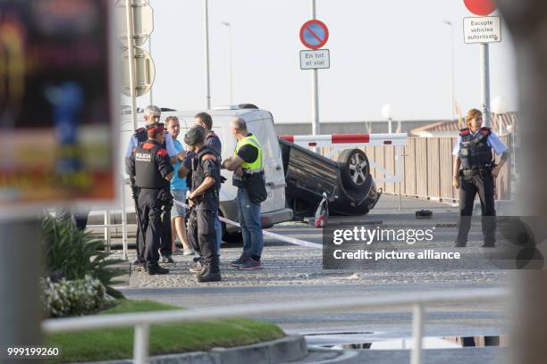 Police officers speaking next to a rolled over car at the location where police shot dead five terrorists in Cambrils, Spain, 18 August 2017. Police...