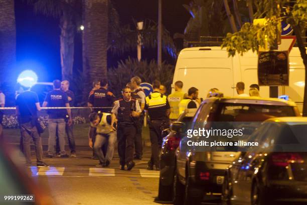 Police officers standing in the early morning at the location where police shot dead five terrorists in Cambrils, Spain, 18 August 2017. Police...