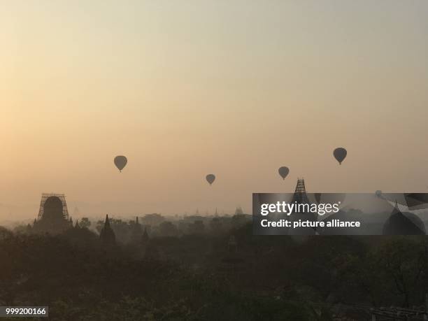 File picture dated 24 February 2017 showing hot-air balloons floating at sunrise over the old royal city of Bagan in Myanmar. Almost 400 temples were...