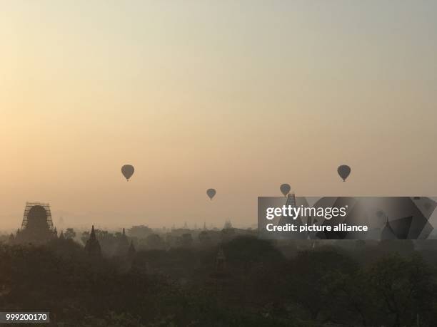 File picture dated 24 February 2017 showing hot-air balloons floating at sunrise over the old royal city of Bagan in Myanmar. Almost 400 temples were...