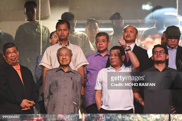 Philippine President Rodrigo Duterte gestures next to Malaysian Prime Minister Mahathir Mohamad after Philippines' Manny Pacquiao beat Argentina's...