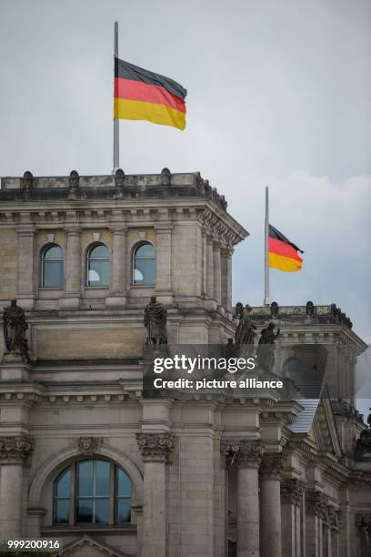 Two German flags flying at half mast in front of the Reichstag building in Berlin, Germany, 18 August 2017. Flags are being flown at half mast in all...