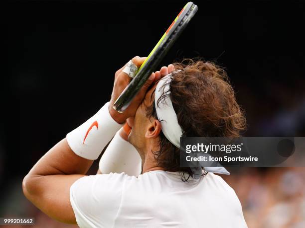 Rafael Nadal reacts after loosing a point in the 5th set during the men's singles semi final at the Wimbledon Championships on July 14, 2018 played...
