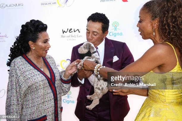 Actress Holly Robinson Peete shares her puppy with singer Smokey Robinson at The HollyRod Foundation's 20th Annual DesignCare Gala at Private...