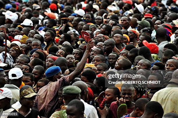 Burundi's Nkurunziza on God and grassroots development** A Burundian policeman uses a flip flop in an attempt to keep a crowd at bay during a...