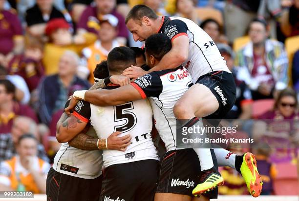 Isaac Luke of the Warriors is congratulated by team mates after scoring a try during the round 18 NRL match between the Brisbane Broncos and the New...