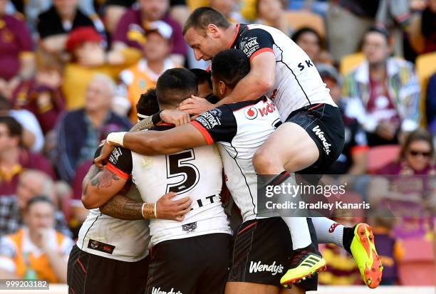 Isaac Luke of the Warriors is congratulated by team mates after scoring a try during the round 18 NRL match between the Brisbane Broncos and the New...