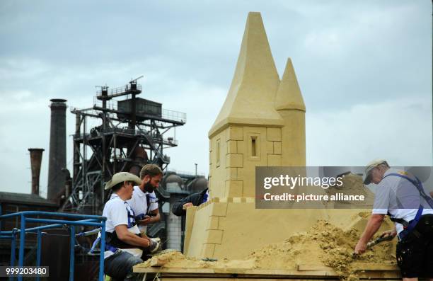 'Sand carvers' work on the sandcastle at the Landschaftspark Nord in Duisburg, 17 August 2017.With a hight of 15,50 metres the castle shall break the...