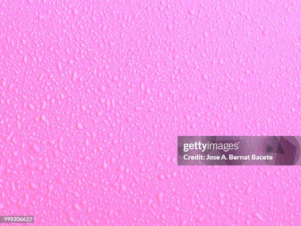 full frame of the textures formed by the bubbles and drops of water, on a smooth  light pink background. - bernat bacete stock-fotos und bilder