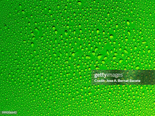 full frame of the textures formed by the bubbles and drops of water, on a smooth light green background. - bernat stock-fotos und bilder