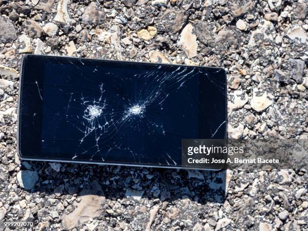 mobile phone with broken glass abandoned on the street floor. - bernat bacete imagens e fotografias de stock