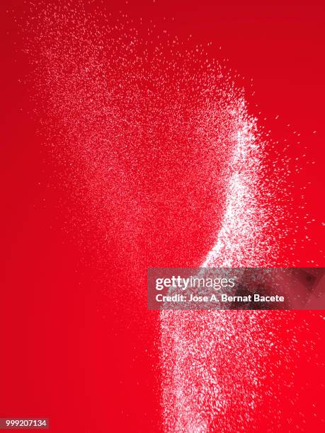 explosion by an impact of a cloud of particles of powder of color white on a red background. - bernat bacete imagens e fotografias de stock