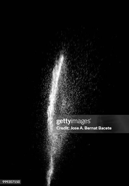 explosion by an impact of a cloud of particles of powder of color white on a black background. - bernat bacete stock-fotos und bilder