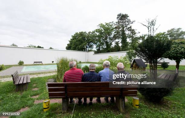 Four inmates of the prison sit on a bench in the courtyard of the jail in Singen, Germany, 27 July 2017. All four of them are senior citizens....