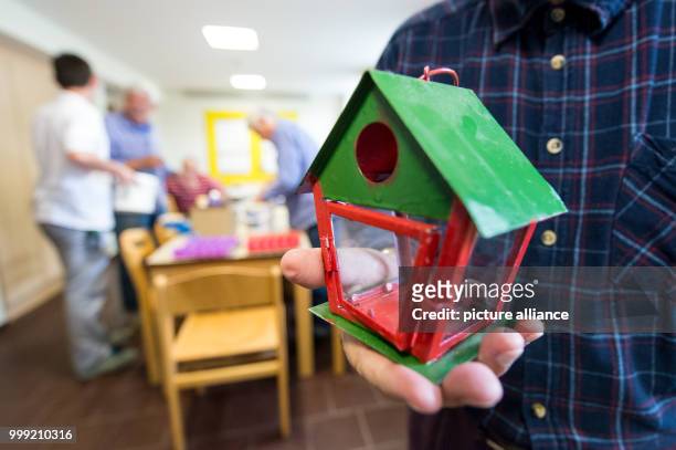 An inmate holds a bidrhouse in his hands in the craft room of the prison in Singen, Germany, 27 July 2017. Nationwide this is the only prison for the...