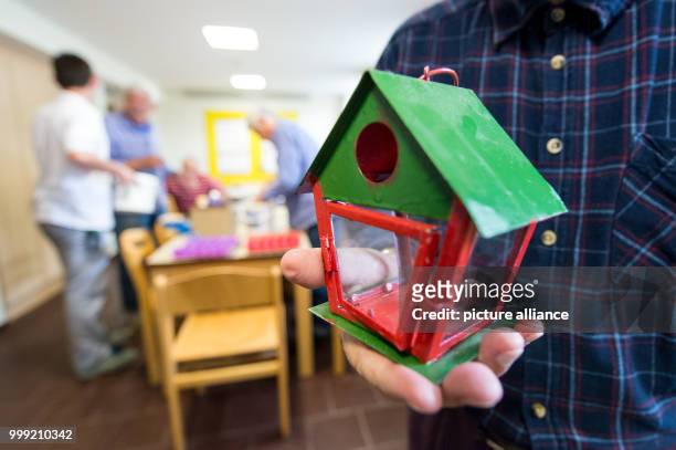 Dpatop - An inmate holds a bidrhouse in his hands in the craft room of the prison in Singen, Germany, 27 July 2017. Nationwide this is the only...