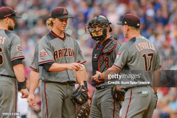 Arizona manager Corey Lovullo removes pitcher Zack Greinke from the game after throwing 7 2/3's innings of shutout baseball during the game between...