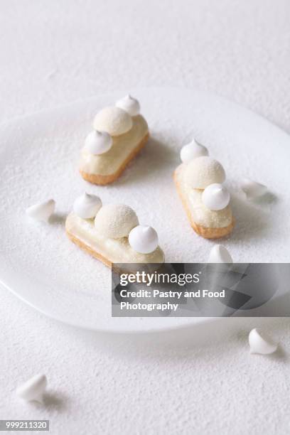 contemporary white chocolate and coconut eclairs - glazed food - fotografias e filmes do acervo