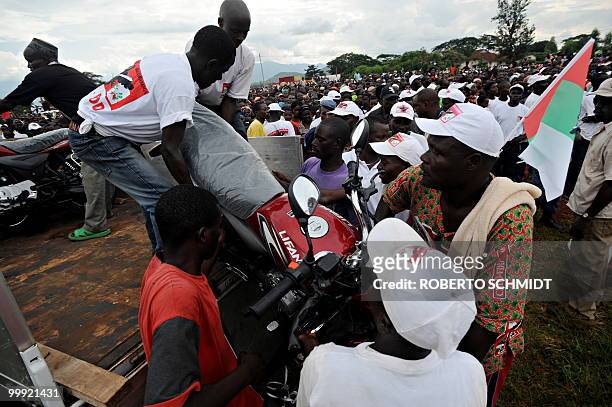 Burundi's Nkurunziza on God and grassroots development** Members of the political party of Burundian President Pierre Nkurunziza unload one of 6...