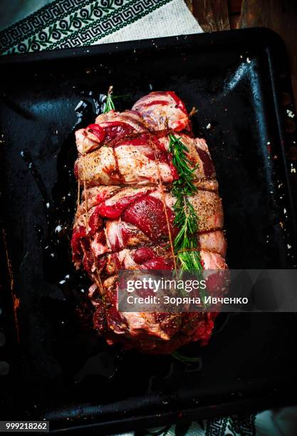 crude lamb leg for roasting on a baking sheet. - leg of lamb 個照片及圖片檔