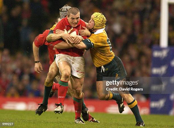 Iestyn Harris of Wales is tackled by Elton Flatley of Australia during the match between Wales and Australia at the Millennium Stadium, Cardiff....