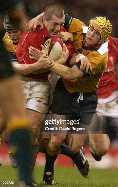 Elton Flatley and Stephen Larkham of Australia try to stop Iestyn Harris of Wales during the match between Wales and Australia at the Millennium...