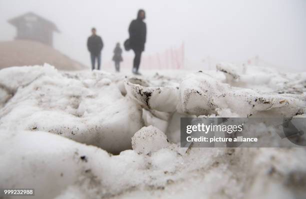 Day trippers hike during rain and fog across the glacier at the Zugspitze in Grainau, Germany, 19 August 2017. Photo: Sven Hoppe/dpa