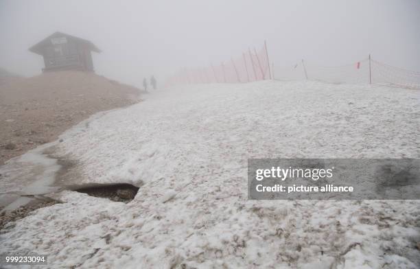 Day trippers hike during rain and fog across the glacier at the Zugspitze in Grainau, Germany, 19 August 2017. Photo: Sven Hoppe/dpa