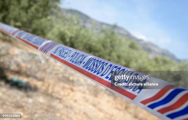 Warning tape of the police can be seen where a residential house exploded on 16 August 2017 in front of a neighbouring field with olive trees in...