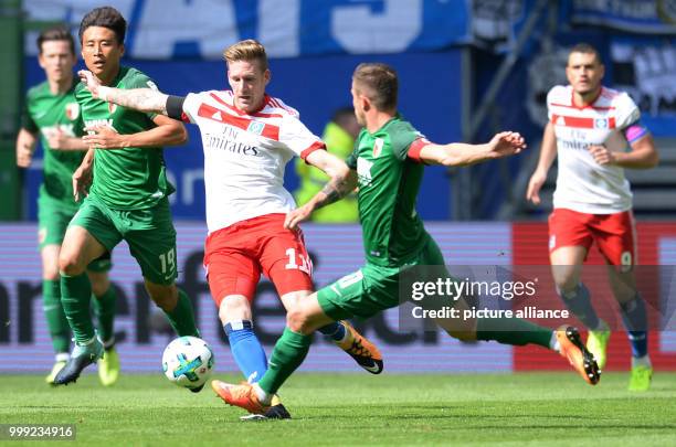 Hamburg's André Hahn and Augsburg's Daniel Baier vie for the ball during the German Bundesliga soccer match between Hamburger SV and FC Augsburg in...