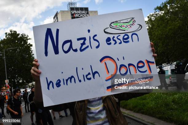 'Nazis essen heimlich Döner' can be seen on a sign of a counter protestor during a demonstration against the neo-Nazi march on the occasion of the...