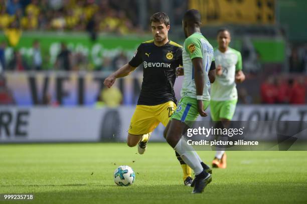 Dortmund's Sokratis and Wolfsburg's Riechedly Bazoer vie for the ball during the German Bundesliga soccer match between VfL Wolfsburg and Borussia...