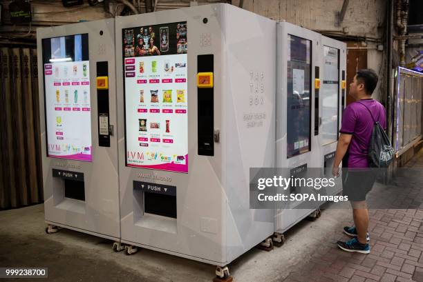 Man purchases snacks and beverages at a new interactive digital vending machine at an industrial area in Hong Kong.