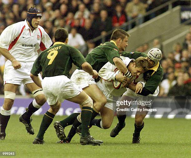 Jonny Wilkinson of England gets wrapped up by Bob Skinstad and Louis Koen of South Africa during the Test Match played between South Africa and...