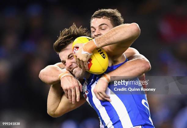 Luke McDonald of the Kangaroos is tackled by Tom Papley of the Swans during the round 17 AFL match between the North Melbourne Kangaroos and the...