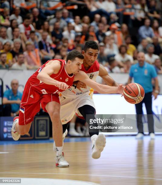 Germany's Maodo Lo and Serbia's Dragan Milosavljevic vie for the ball during the basketball Super Cup fixture betweem Germany and Serbia in the...