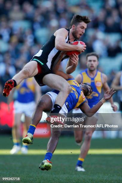 Tom Phillips of the Magpies and WIllie Rioli of the Eagles collide during the round 17 AFL match between the Collingwood Magpies and the West Coast...