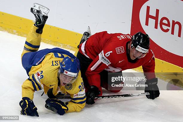 Andreas Engqvist of Sweden is challenged by Timo Helbling of Switzerland during the IIHF World Championship group E qualification round match between...