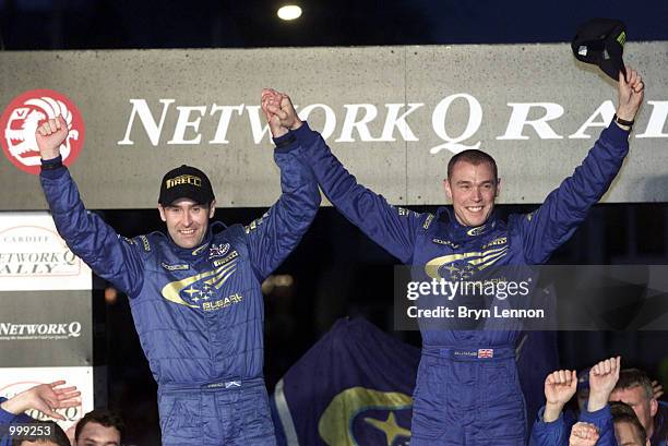 Richard Burns and co-driver Robert Reid of England and Subaru celebrates their World Championship victory and third place in the Network Q Rally of...