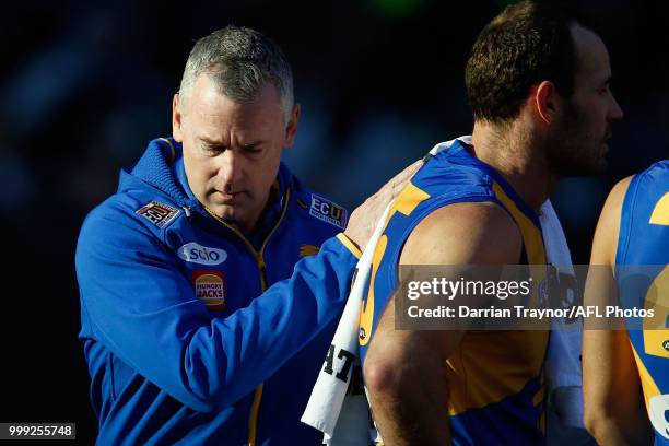 Adam Simpson, Senior Coach of the Eagles pats Shannon Hurn on the back during the round 17 AFL match between the Collingwood Magpies and the West...