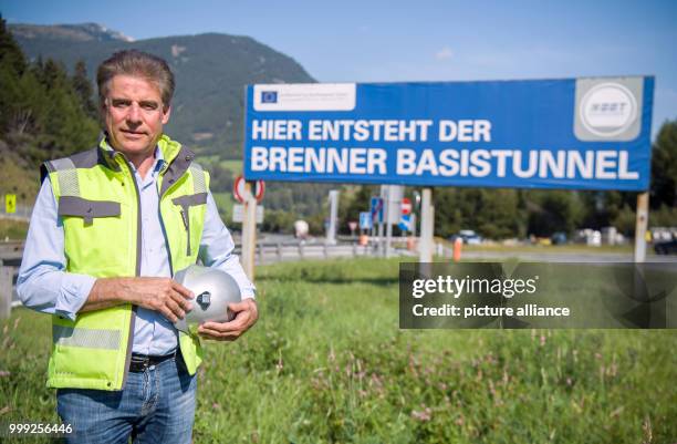 Tunnel boss Konrad Bergmeister standing by a sign announcing the creation of the Brenner Base Tunnel at a construction site beside a motorway near...