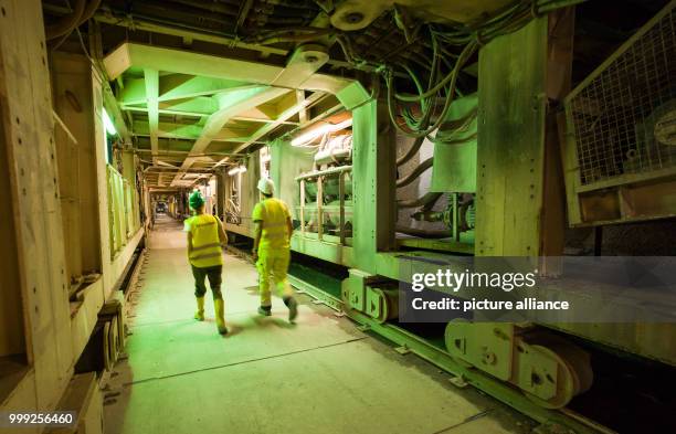 Two people walking under the tunnel drilling machine in a section of construction site for the Brenner Base Tunnel near Innsbruck, Austria, 18 August...