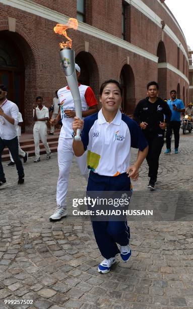 Indian boxer Mary Kom takes part in the 2018 Asian Games torch relay in New Delhi on July 15, 2018.