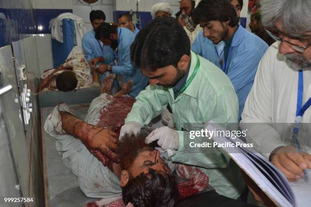 Doctors attending to a victim of a suicide bombing attack on a Balochistan Awami Party corner meeting at Mastang district, At least 160 people were...