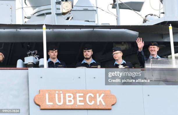 Crew member of frigate "Luebeck" waves as the ship sets off from the naval base in Wilhelmshaven, Germany, 21 August 2017. The ship is taking part in...