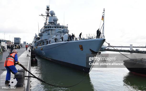 Dock worker releases the moorings from the frigate "Luebeck" as it sets off from the naval base in Wilhelmshaven, Germany, 21 August 2017. The ship...